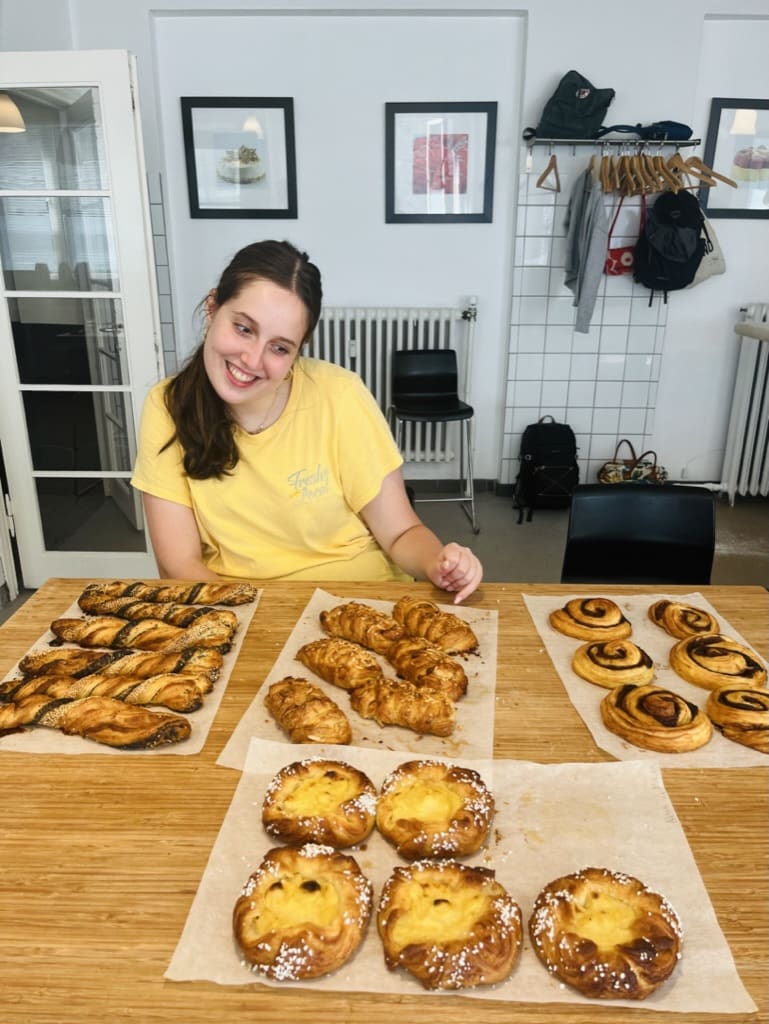 Hands-on Danish pastry baking workshop in Copenhagen, with pastries on trays and participants preparing dough.