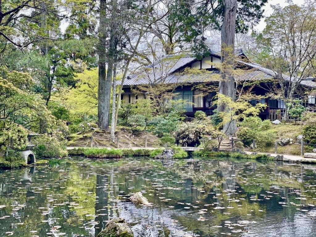 Traditional Japanese garden with pond and wooden temple building in Kyoto, Japan
